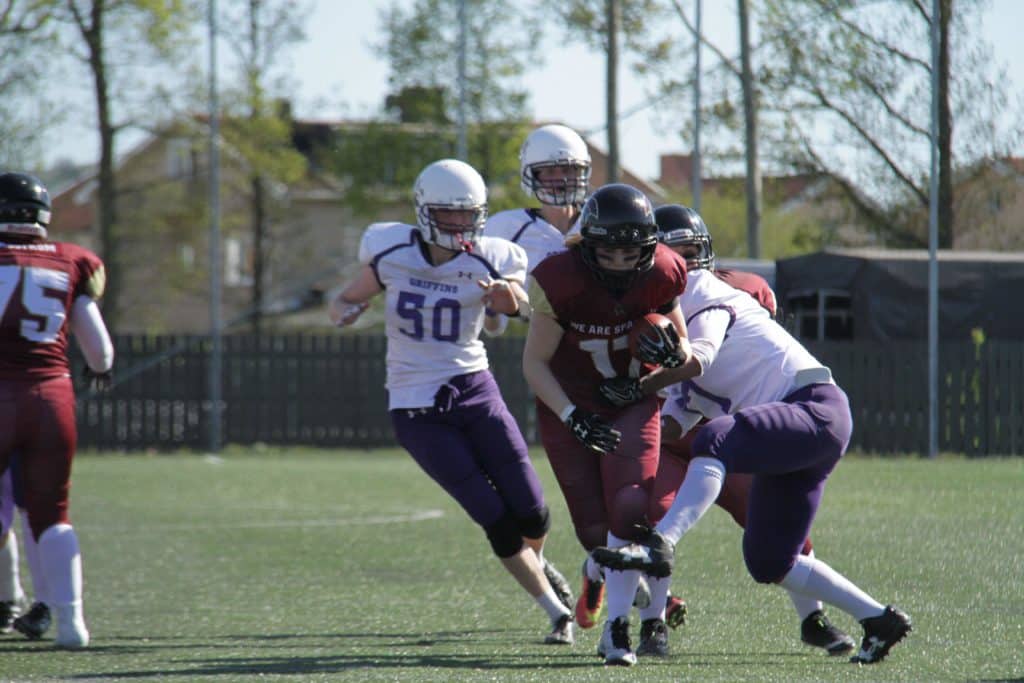 Players running with ball during competitive outdoor football