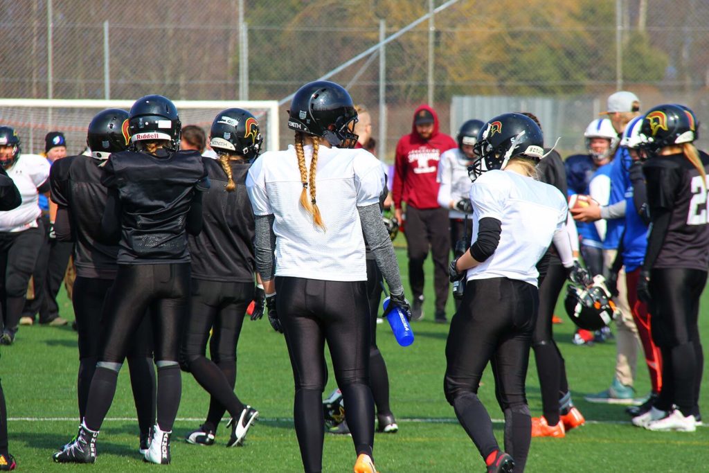 Women in black football gear on turf field