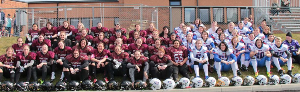 Smiling women football teams posing for group photo.