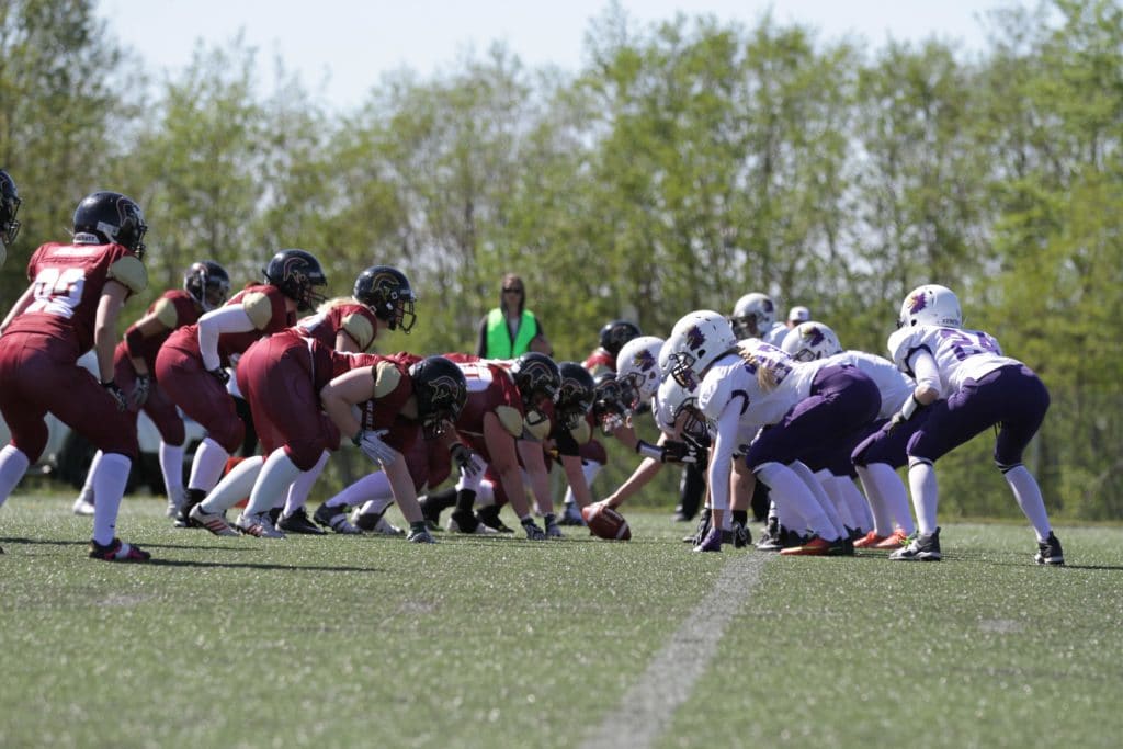 Two womens football teams facing off outdoors.