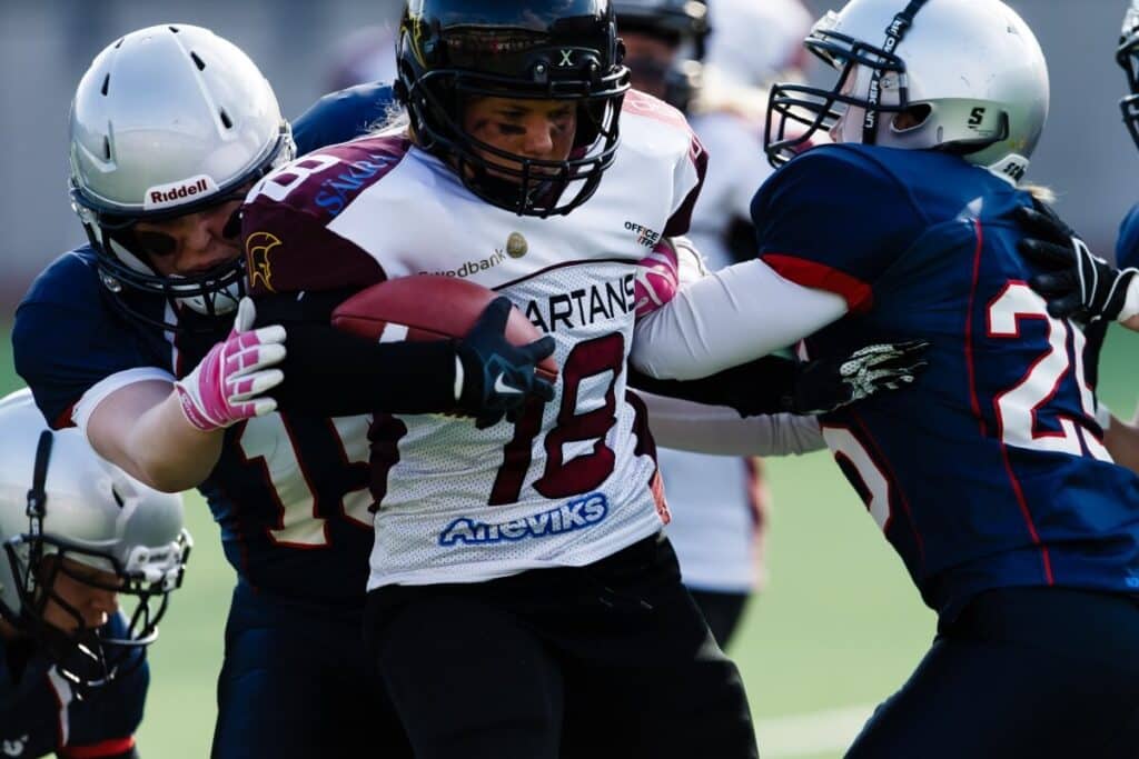 Female football player tackled while carrying the ball