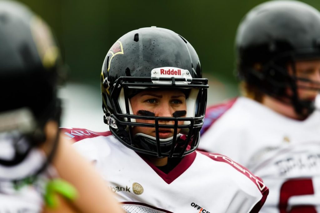 Female football player wearing Riddell helmet and eye