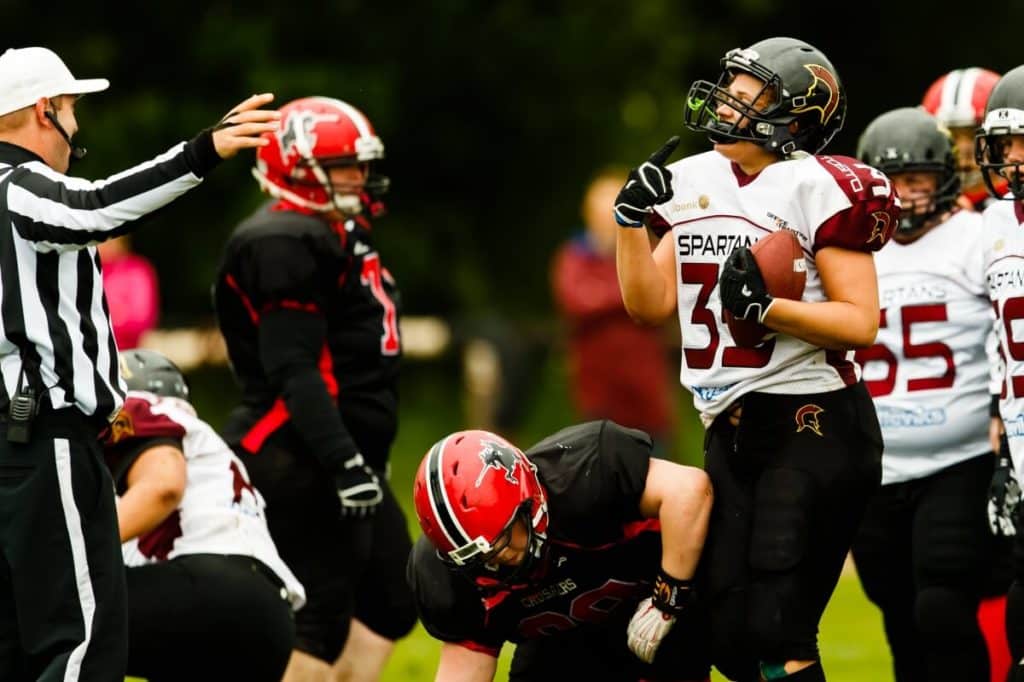 Referee instructs female football player holding ball