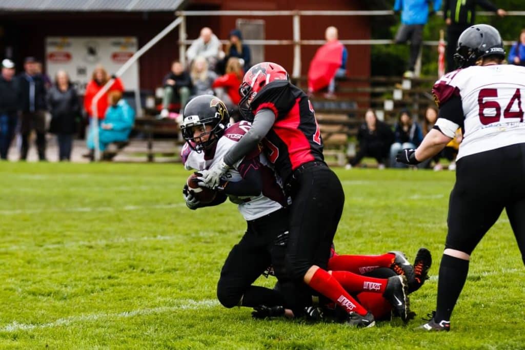 Intense tackle during womens football game outdoors.