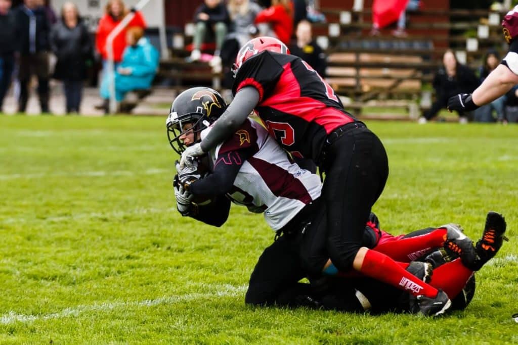 Two players tackling fiercely during outdoor football game
