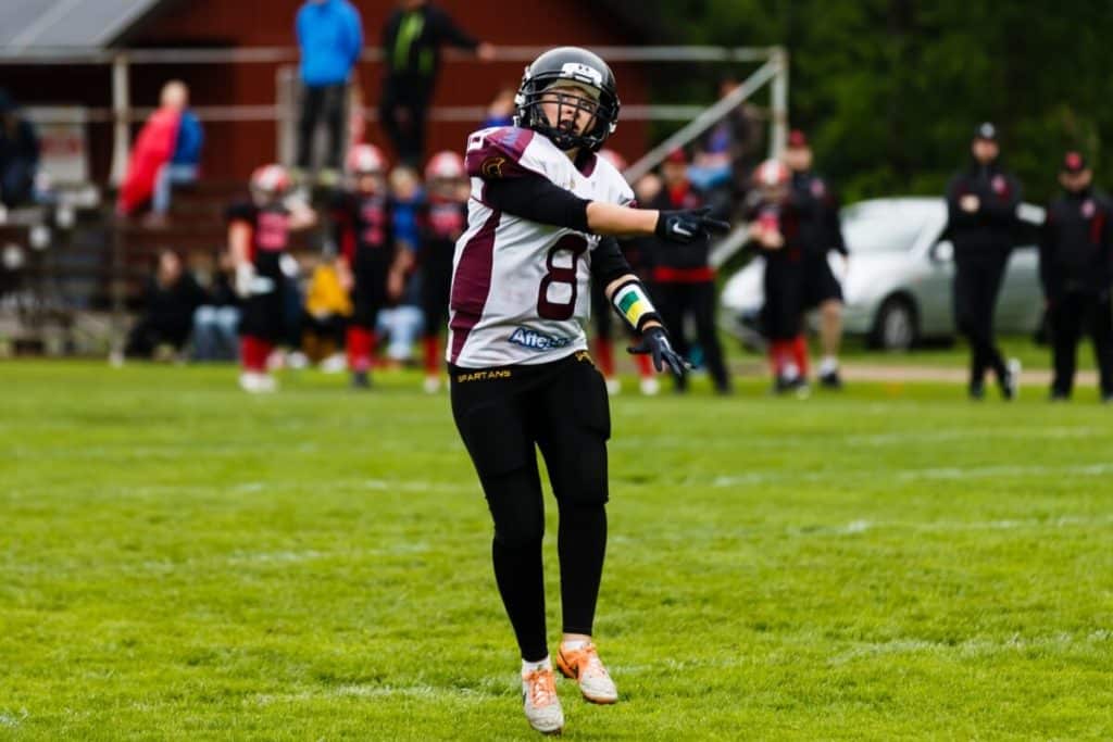 Female football player standing on green field outdoors