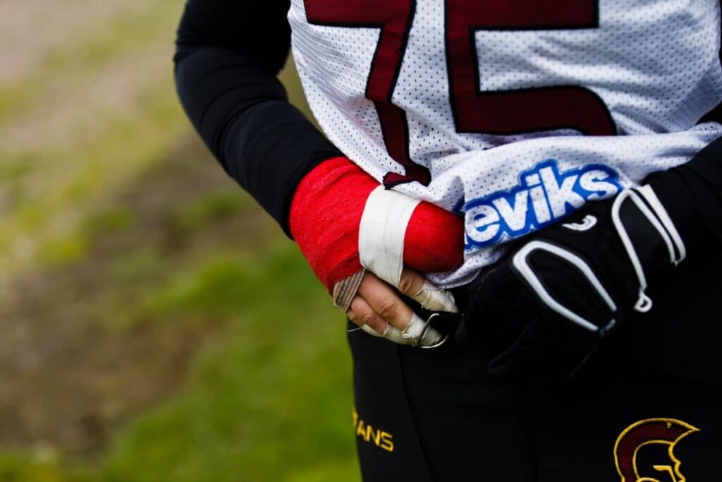 Athletes hand wrapped tightly in red athletic tape.