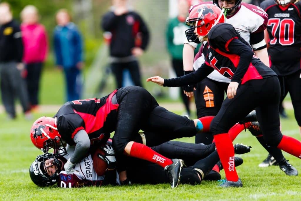 Intense womens football tackle during active outdoor game.