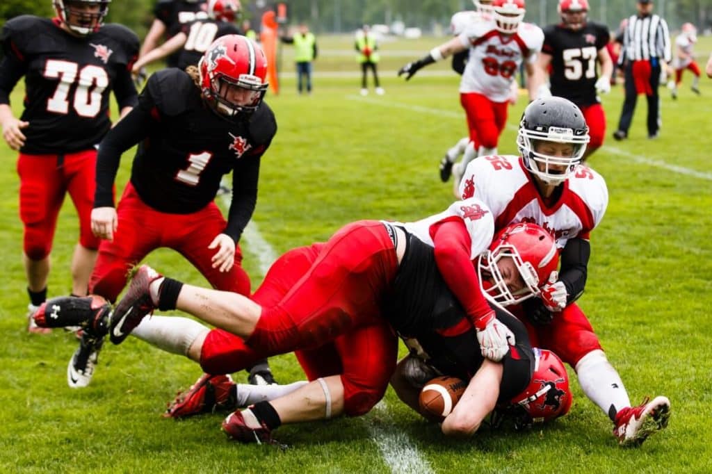 Football players tackling fiercely during a competitive game.