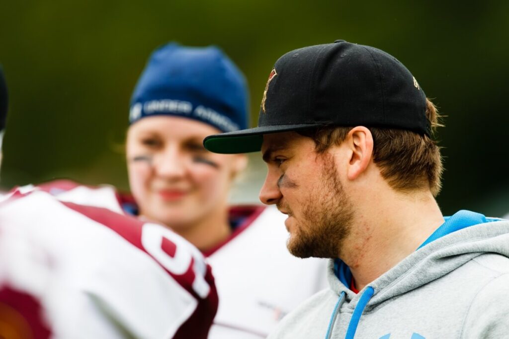 Man in black cap and woman athlete outdoors