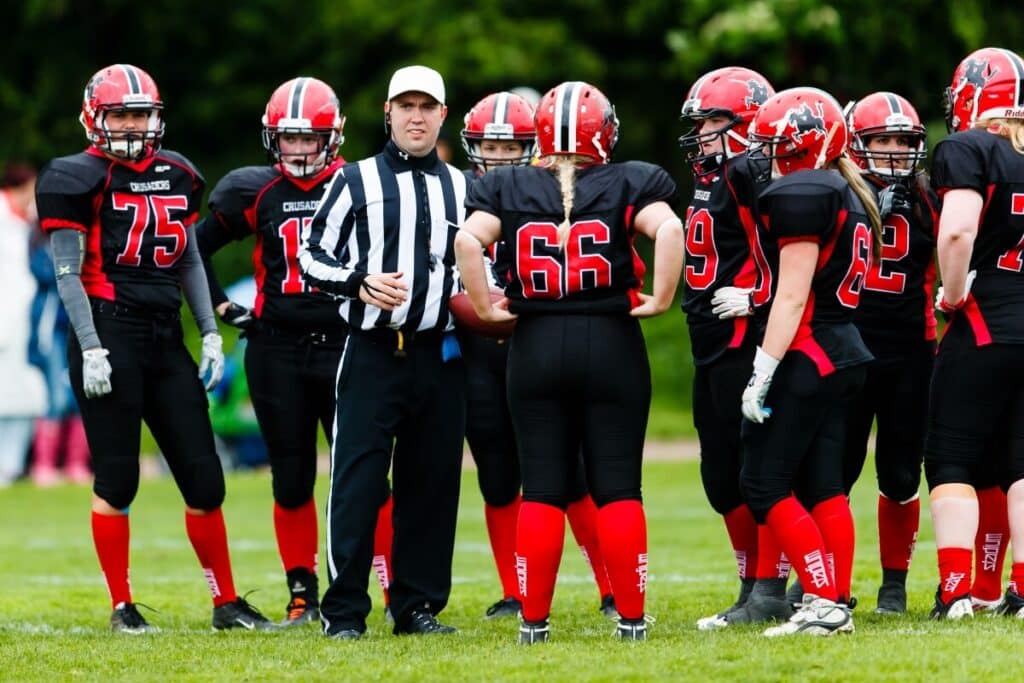 Referee speaking to womens football team huddle