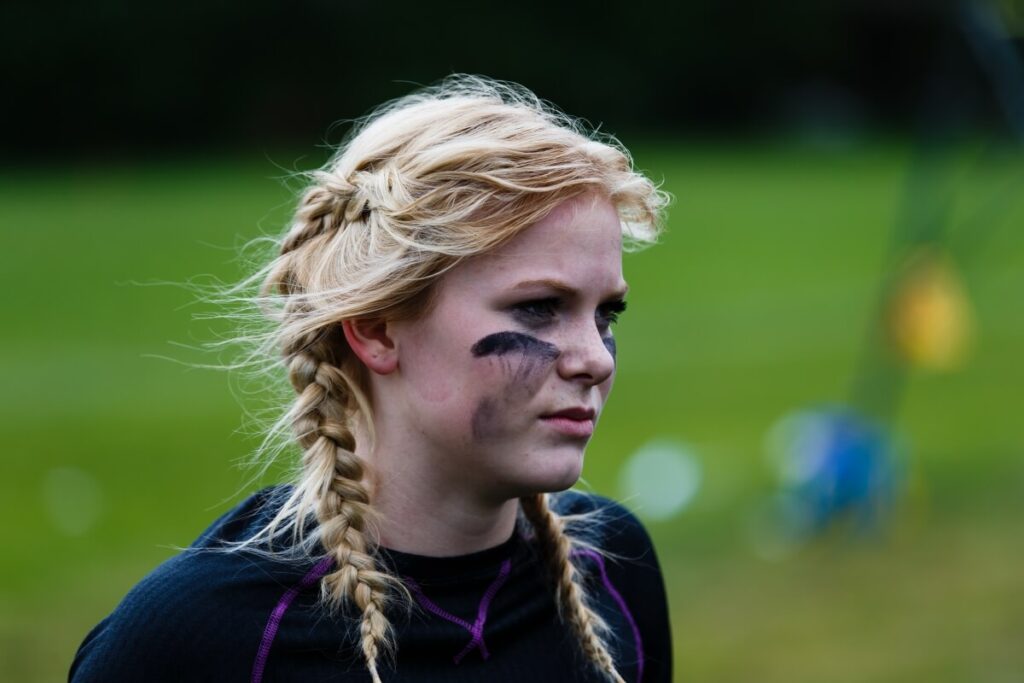 Blonde girl with braided pigtails and eye black