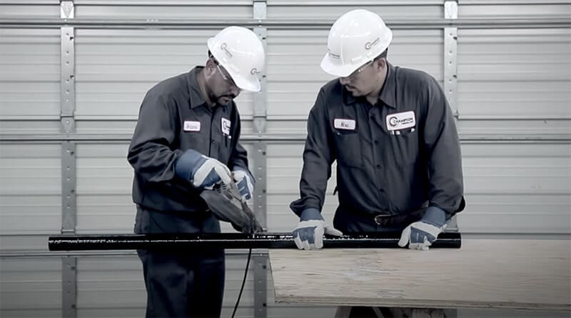 A portable bandsaw cuts fiberglass conduit