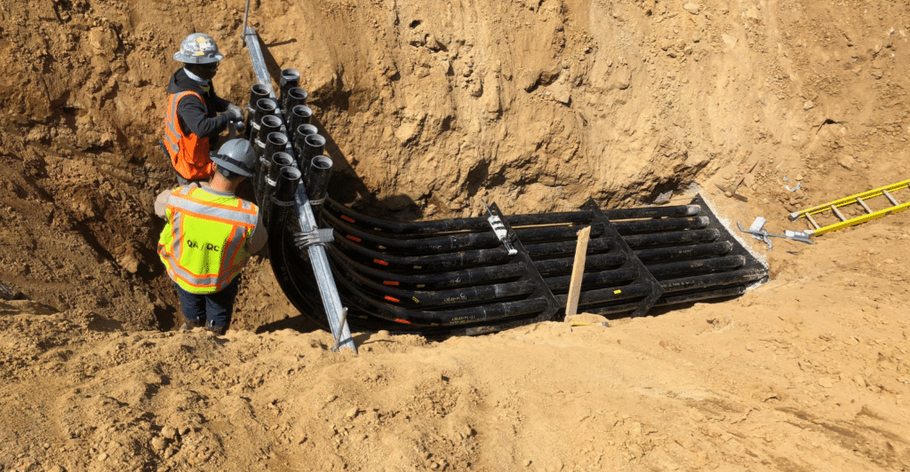 Elbows in ground with two workers