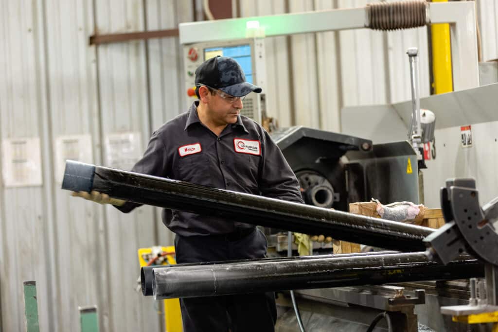 A Champion Fiberglass manufacturing worker inspects electrical conduit.